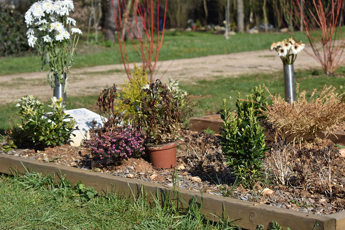 La tombe d'un·e défunt·e, garnie de nombreuses fleurs